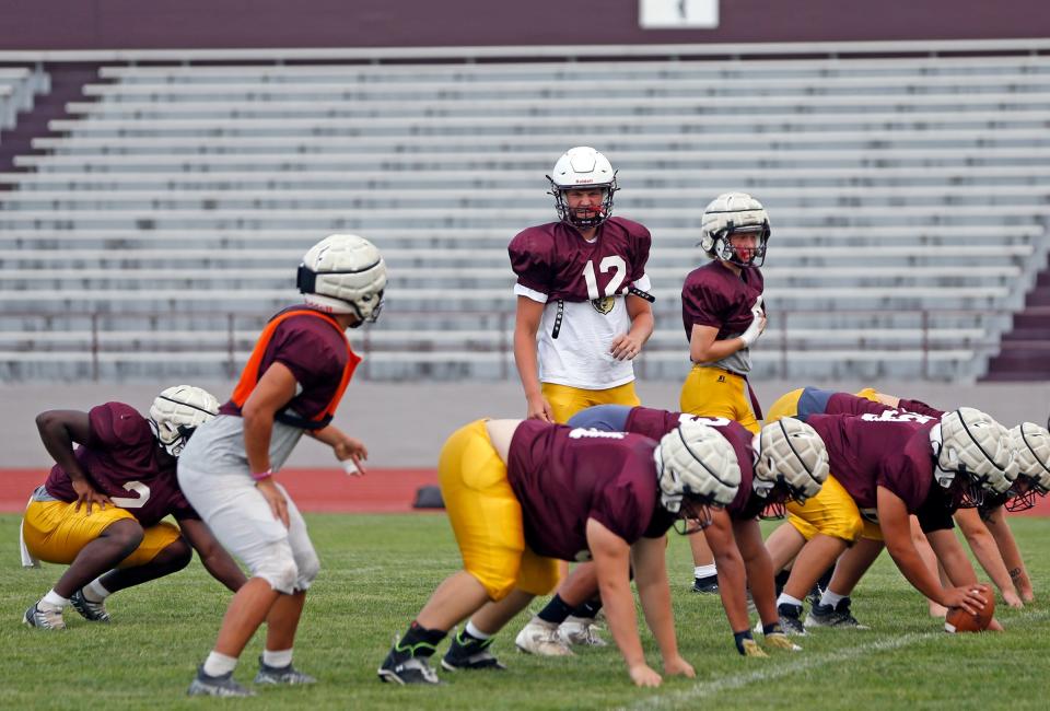 Mishawaka senior Brady Fisher (12) yells out instructions before a play in practice Tuesday, August 8, 2023, at Mishawaka High School.
