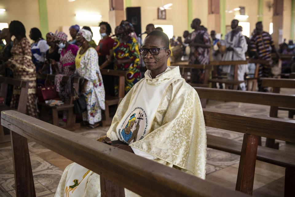 Noel Henri Zongo, a priest at the Church of the Sangoulé Lamizana military camp in Ouagadougou, Burkina Faso, poses for a portrait Sunday, April 11, 2021. Just seven chaplains, hailing from Protestant, Catholic and Muslim faiths, are charged with spiritually advising some 11,000 soldiers and helping maintain their morale. The troops “face death every day. ... At this moment they also need to have much more spiritual help,” he says. (AP Photo/Sophie Garcia)