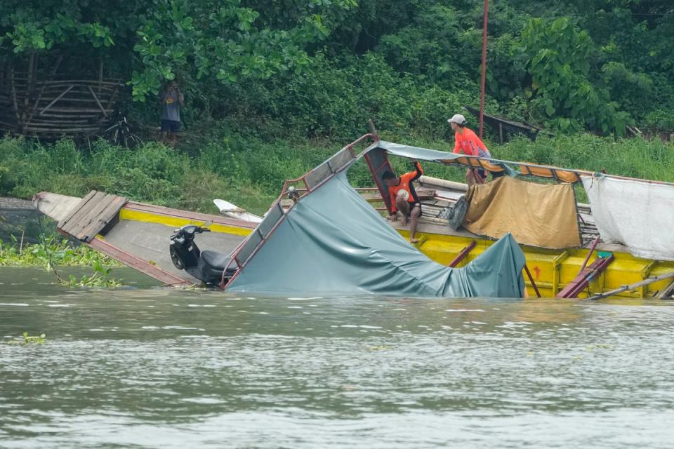 Rescuers check the capsized passenger boat in Binangonan, Rizal province, Philippines (AP)
