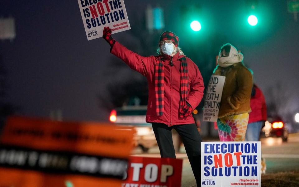 Activists in opposition to the death penalty gather to protest the execution of Lisa Montgomery - Bryan Woolston/Reuters