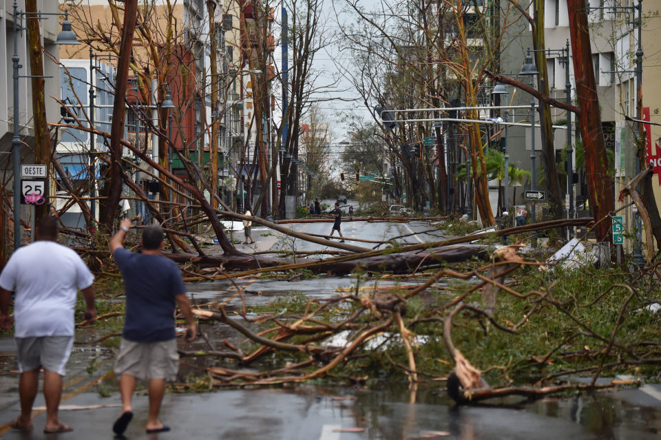 <p>Men walk damaged trees after the passage of Hurricane Maria, in San Juan, Puerto Rico, on Sept. 20, 2017. (Photo: Hector RetamalAFP/Getty Images) </p>