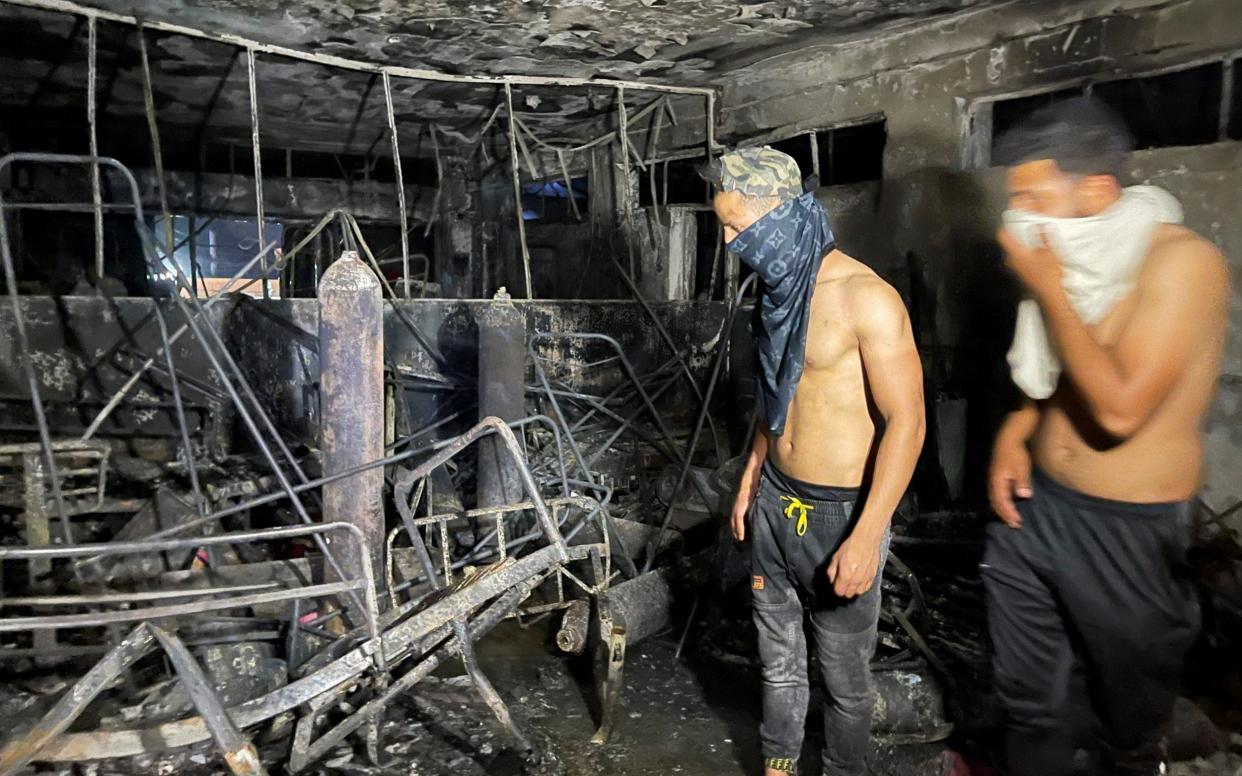 People look on at Ibn Khatib hospital after a fire caused by an oxygen tank explosion - Reuters