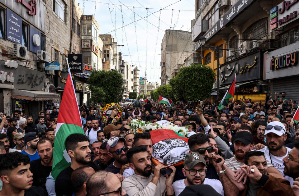 Palestinians carry the flag-draped body of veteran Al-Jazeera journalist Shireen Abu Akleh