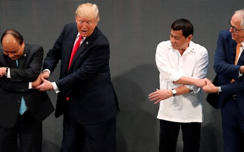 U.S. President Donald Trump registers his surprise as he realises his mistake for the traditional "ASEAN handshake" - Credit: Reuters