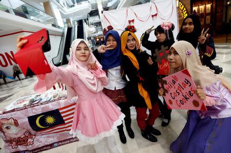 FILE PHOTO: Muslim women cosplayers take a selfie during a cosplay event at a mall in Petaling Jaya, near Kuala Lumpur, Malaysia July 8, 2017. REUTERS/Lai Seng Sin/File Photo