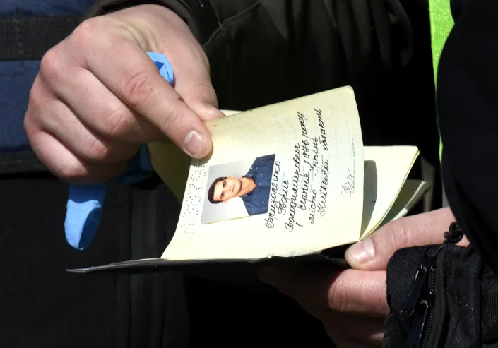 A police officer inspects a passport found in Irpin on April 14 after Russian forces withdrew.