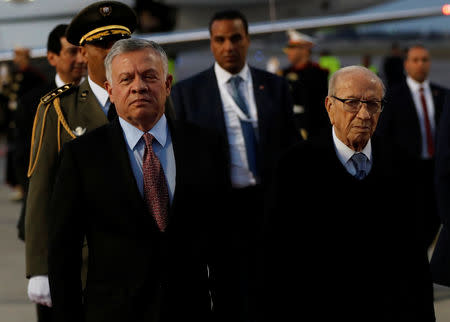 King Abdullah II of Jordan, left, walks next to Tunisian President Beji Caid Essebsi, as they review an honor guard, upon his arrival at Tunis-Carthage international airport to attend the Arab Summit, in Tunis, Tunisia March 30, 2019. Hussein Malla/Pool via REUTERS