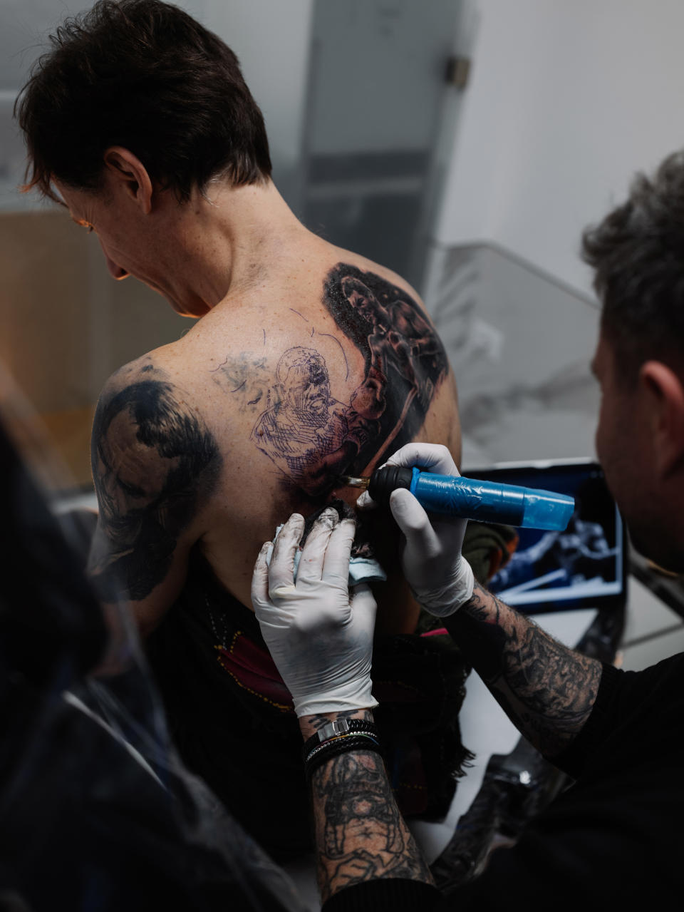 El tatuador Alex De Pase atiende a un cliente en el estudio de su casa en el pueblo de Grado, Italia, el 7 de abril de 2022. (Ciril Jazbec/The New York Times)