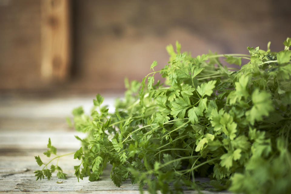 A bunch of fresh parsley on a wooden surface