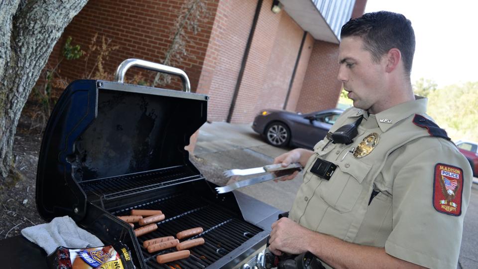 Neil Jenkins, Madison Police Department shift commander, tries his hand at grilling some hotdogs during National Night Out festivities at the Webster Animal Shelter in Madison on Tuesday, Oct. 3.