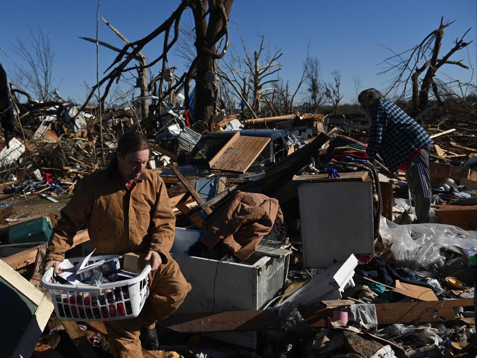 People gather belongings from a tornado damaged home after extreme weather hit the region December 12, 2021, in Mayfield, Kentucky (AFP via Getty Images)