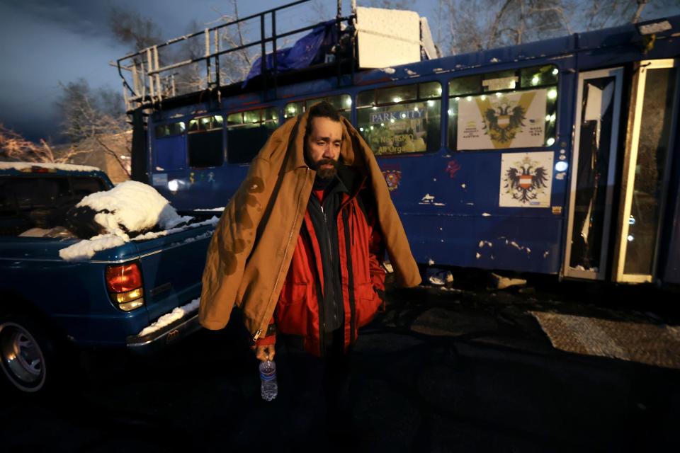 Mike “Trigger” Garcia, who is unsheltered, stands outside of the Nomad Alliance bus in Salt Lake City. 