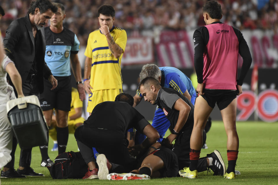 Estudiantes de La Plata's Javier Altamirano is assisted by members of his team during an Argentine soccer league match against Boca Juniors in La Plata, Argentina, Sunday, March 17, 2024. The match was suspended after Altamirano was taken off the field in ambulance.(AP Photo/Ignacio Amiconi )