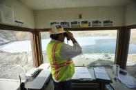 In this March 5, 2020, photo, Mark Thompson, the environmental affairs manager for Montana Resources, scans the water at the Berkeley Pit in Butte, Montana. The Trump administration is moving to scale back criminal enforcement of a century-old law protecting most American wild bird species. Thompson said it would keep up the efforts that drive away almost all birds regardless of the Trump administration’s actions, mirroring pledges from some other companies and industries. (Meagan Thompson/The Montana Standard via AP)