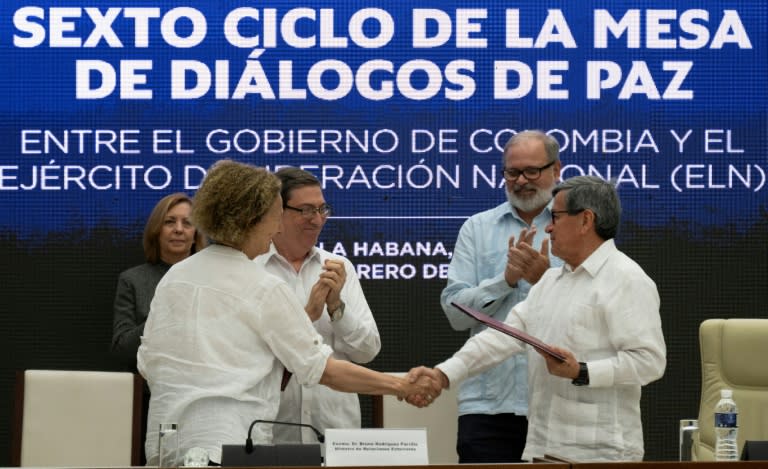 La representante del gobierno colombiano, Vera Grabe (izq), y el jefe negociador del ELN, Pablo Beltrán, se dan la mano tras firmar un acuerdo de extensión del alto el fuego, el 6 de febrero de 2024 en La Habana (Yamil Lage)