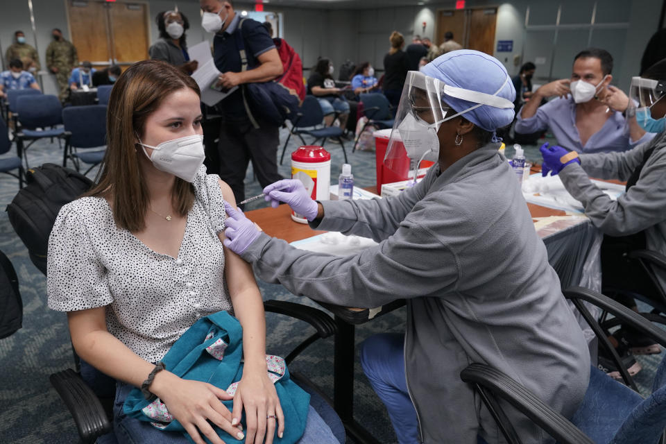 Natalia Dubom, of Honduras, gets the Johnson & Johnson COVID-19 vaccine at Miami International Airport, Friday, May 28, 2021, in Miami. The vaccine was offered to all passengers arriving at the airport. Florida's Emergency Management Agency is running the program through Sunday. (AP Photo/Marta Lavandier)