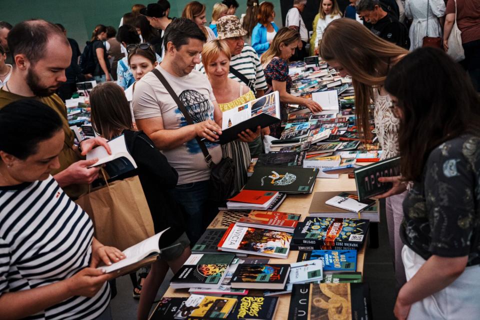 People look at books arrayed on a table