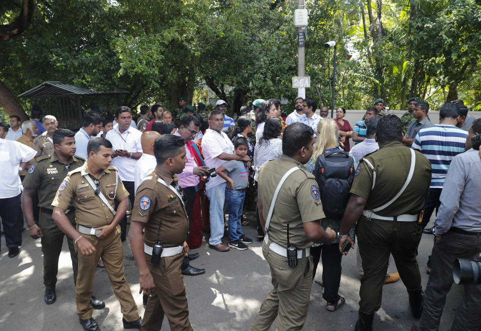 A group of policemen arrive as supporters and media personnel wait outside the residence of Sri Lanka's former defense secretary and presidential candidate Gotabaya Rajapaksa in Colombo, Sri Lanka, Sunday, Nov.17, 2019. Sri Lanka’s ruling party presidential candidate conceded defeat on Sunday to Rajapaksa, marking the return of a family revered by the Sinhalese Buddhist majority for the victory over the Tamil Tiger rebels but feared by Tamil and Muslim minorities. (AP Photo/Eranga Jayawardena)