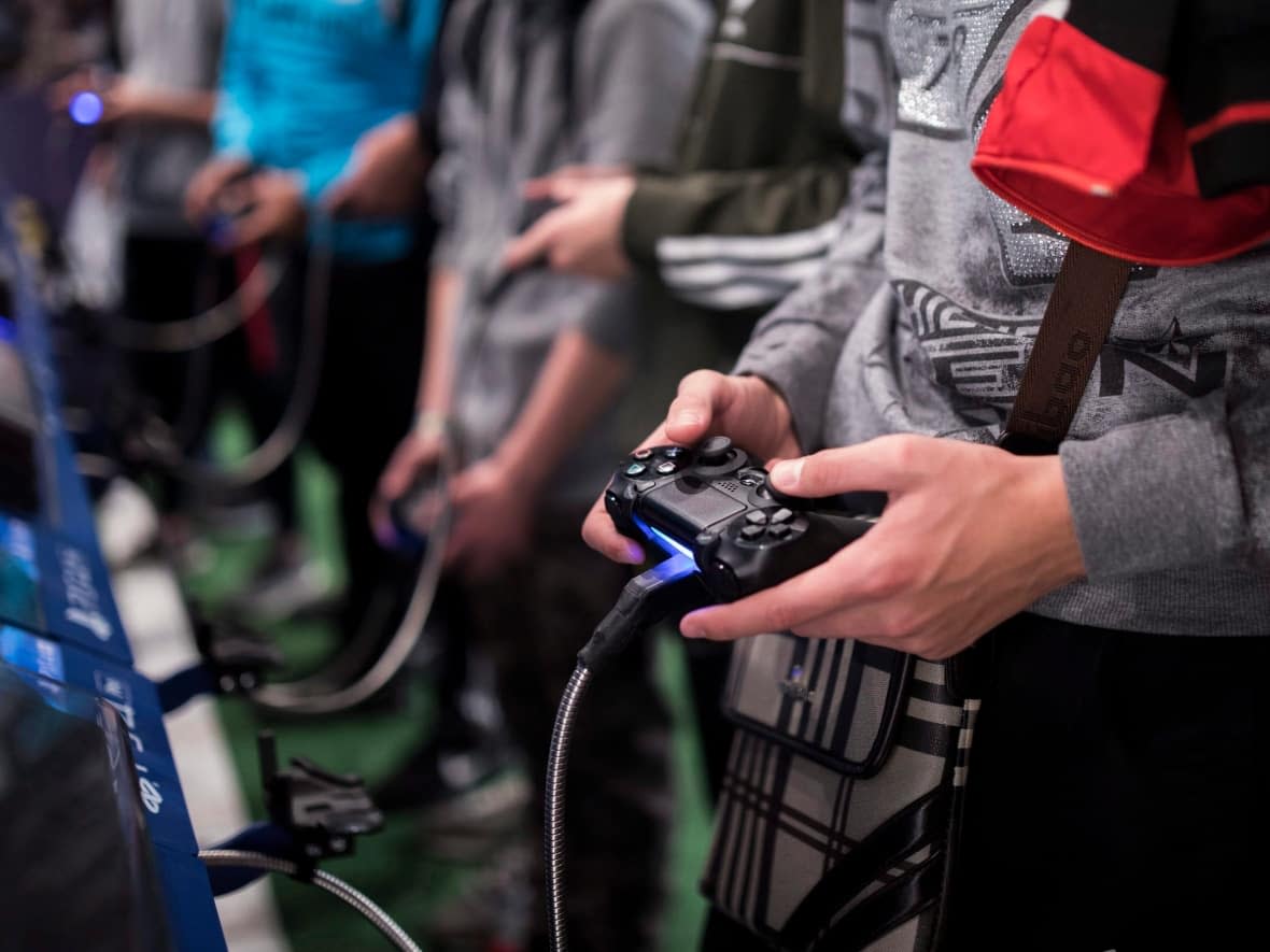 Some skilled workers in the video game industry are already saying 'it's time for me to pack up and leave' because of Bill 96, one insider said.  (Kamil Zihnioglu/The Associated Press - image credit)