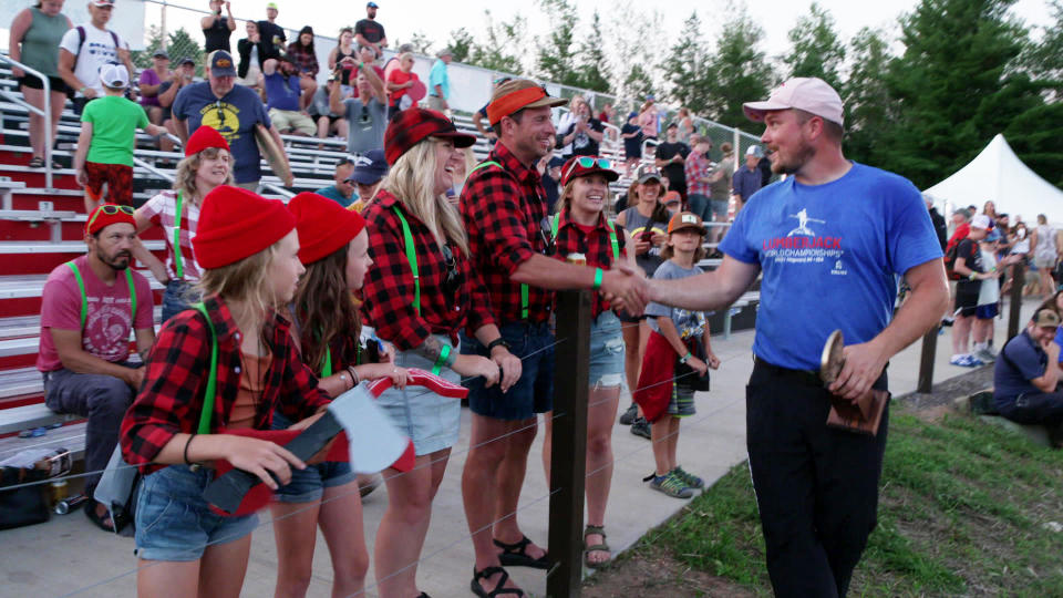 Champion Matt Cogar greets some appropriately-attired lumberjack fans.  