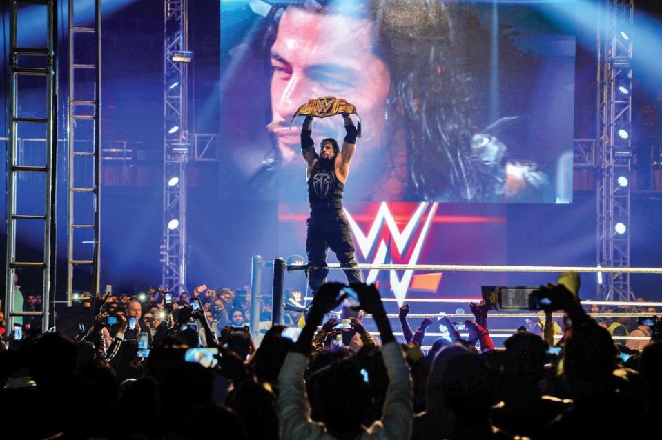 In this photograph taken on January 15, 2016, wrestler Roman Reigns holds up the Championship Belt during the World Wrestling Entertainment (WWE) Live India Tour in New Delhi.    Enthusiastic fans flocked to the event as WWE returned to the country after an interval of 13 years.   AFP PHOTO/ CHANDAN KHANNA / AFP / Chandan Khanna        (Photo credit should read CHANDAN KHANNA/AFP via Getty Images)