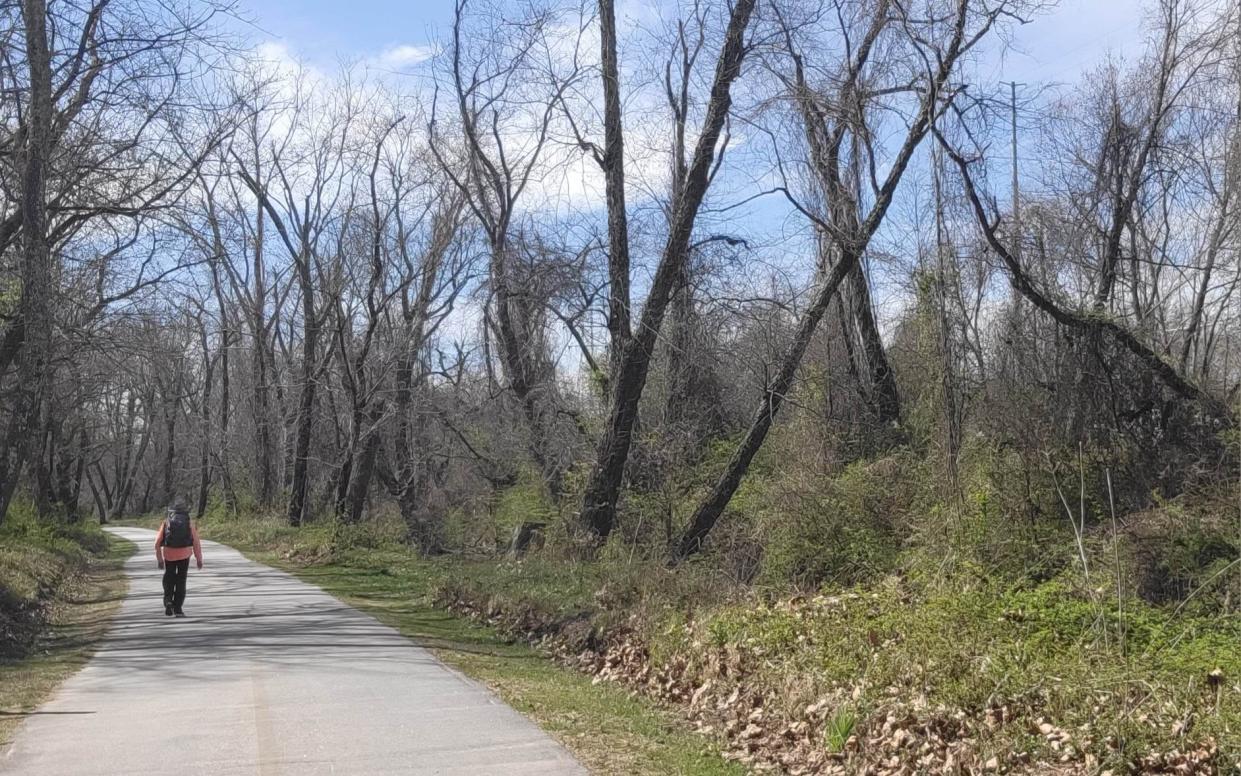 A woman walks along the Oklawaha Greenway earlier this month.