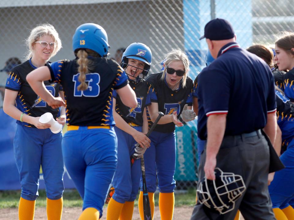 Olivia Winland is met at home plate by her teammates after hitting a home run in the seventh inning of Philo's 15-9 win against host West Muskingum on Thursday in Falls Township. The Electrics had 17 hits and launched a school-record six homers as they improved to 12-6 overall.
