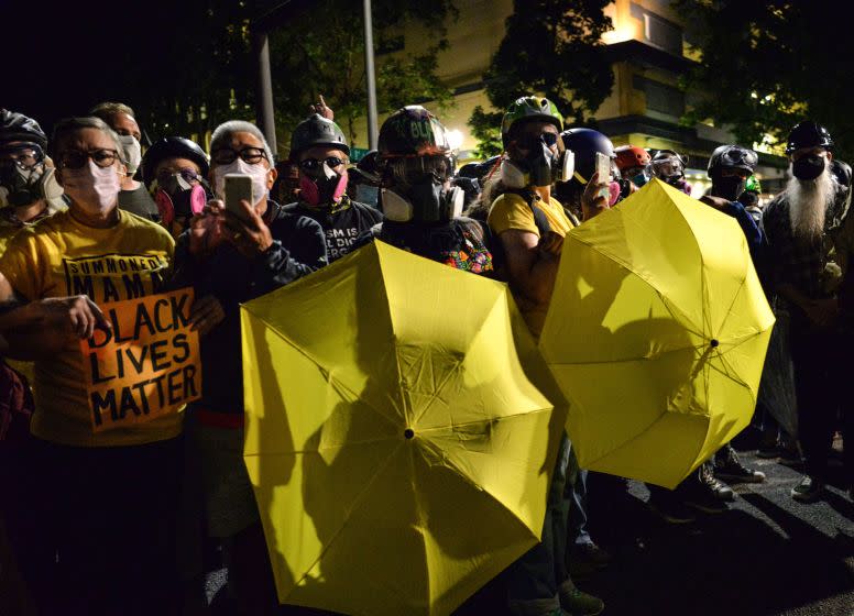 Protestors carry umbrellas as they gather at The Mark O. Hatfield Courthouse in Portland, Oregon late July 25, 2020, as protests continue across the United States following the death in Minneapolis of unarmed African-American George Floyd. - Police and federal agents fired tear gas and forcefully dispersed protesters in the US city of Portland, amid President Donald Trump's heavily-criticized "surge" of security forces to major cities. The city, the biggest in the state of Oregon, has seen nightly protests against racism and police brutality for nearly two months, initially sparked by the death of unarmed African American George Floyd at the hands of police in Minnesota (Photo by Ankur Dholakia / AFP) (Photo by ANKUR DHOLAKIA/AFP via Getty Images)