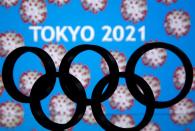 FILE PHOTO: A 3D printed Olympics logo is seen in front of displayed "Tokyo 2021" words in this illustration