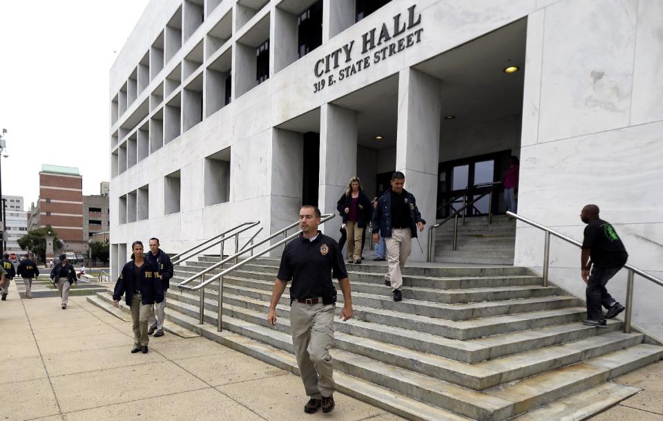 FBI agents leave Trenton City Hall, Thursday, July 19, 2012, in Trenton, N.J. after they raided it. The agents' raid comes a day after they searched the home of Mayor Tony Mack. The mayor on Wednesday denied wrongdoing after the FBI spent the overnight hours searching his home, and the homes of his brother, Ralphiel Mack, and businessman Joseph Giorgianni, a campaign donor who is a convicted sex offender. (AP Photo/Julio Cortez)