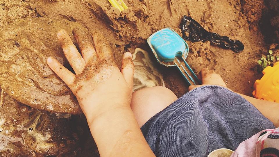 Mano de un niño jugando con tierra