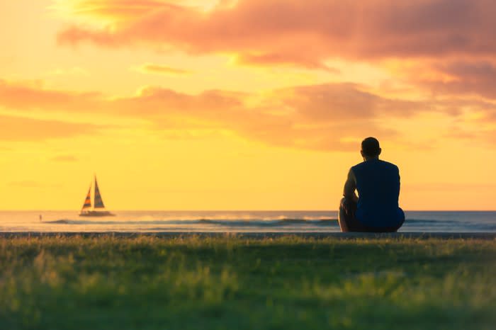 A man on a beach looking out at the horizon