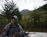 A communal police forest officer rides in the back of a pickup truck along with a volunteer community patrol through the woods looking for illegal logging and avocado planting, on the outskirts of the Indigenous township of Cheran, Michoacan state, Mexico, Thursday, Jan. 20, 2022. Regular citizens have taken the fight against illegal logging into their own hands in the pine-covered mountains of western Mexico. Over the last decade they have seen illegal logging clear the hillsides for plantations of water hungry avocado trees. (AP Photo/Fernando Llano)