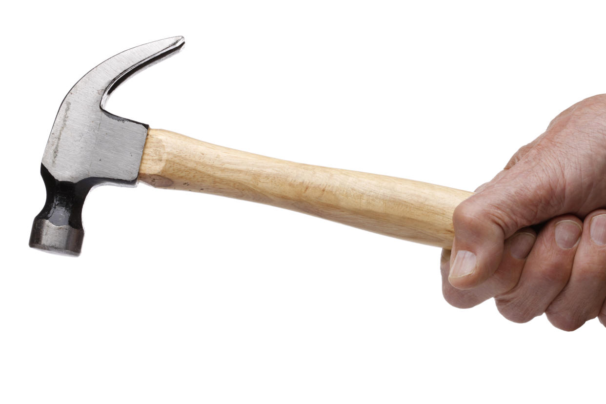 A man's hand holding a hammer. (PHOTO: Getty Images)