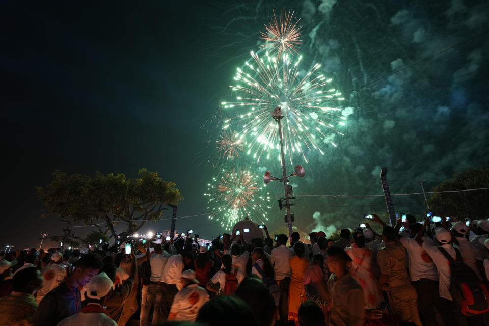 Firecrackers light up the sky over lamps lined on the banks of the river Saryu in Ayodhya, India, Sunday , Oct. 23, 2022. Hindus believe the city is the birthplace of Ram. Millions of people across Asia are celebrating the Hindu festival of Diwali, which symbolizes new beginnings and the triumph of good over evil and light over darkness. (AP Photo/Rajesh Kumar Singh)