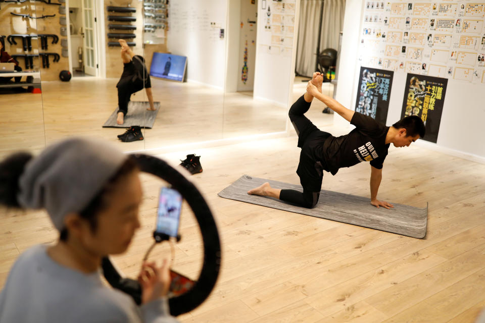 Trainer Wang Kai teaches a class that is being livestreamed at a gym, as the country is hit by an outbreak of the new coronavirus, in Beijing, China February 14, 2020. Picture taken February 14, 2020. REUTERS/Carlos Garcia Rawlins