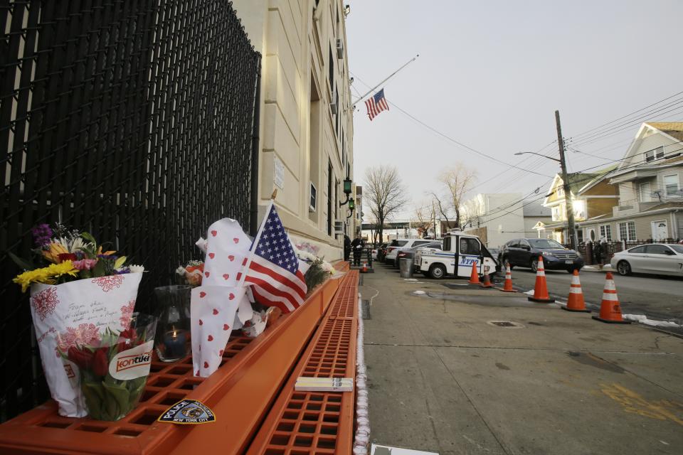 A makeshift memorial is placed near the 102nd precinct Wednesday, Feb. 13, 2019, in New York. Brian Simonsen, a New York City police detective was shot and killed by friendly fire Tuesday night as officers confronted a robbery suspect who turned out to be armed with a replica handgun, Commissioner James O'Neill said. (AP Photo/Frank Franklin II)