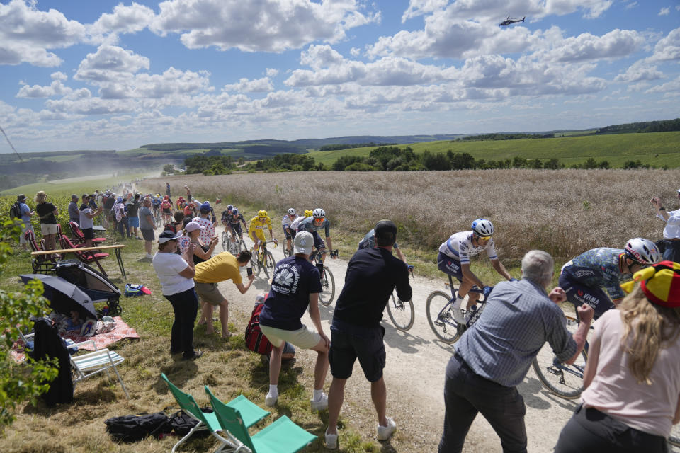 The pack with Slovenia's Tadej Pogacar, wearing the overall leader's yellow jersey, center left, rides on a gravel road during the ninth stage of the Tour de France cycling race over 199 kilometers (123.7 miles) with start and finish in Troyes, France, Sunday, July 7, 2024. (AP Photo/Jerome Delay)