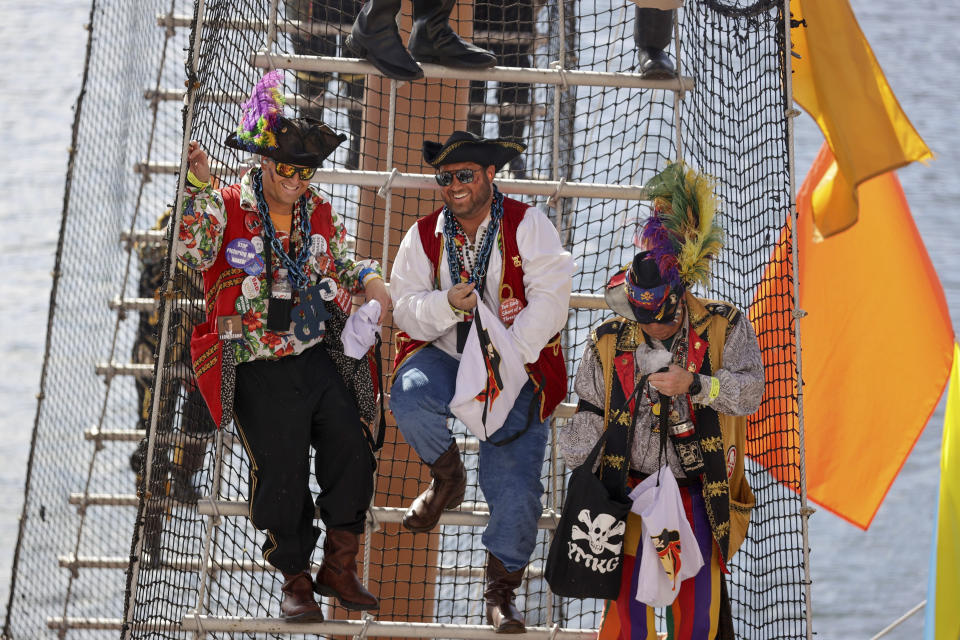 Pirates stand on a mast ladder aboard the Jose Gasparilla pirate ship as it docks at the Tampa Convention Center before the start of the Gasparilla Invasion Parade on Saturday, Jan. 27, 2024, in Tampa. (Louis Santana/Tampa Bay Times via AP)