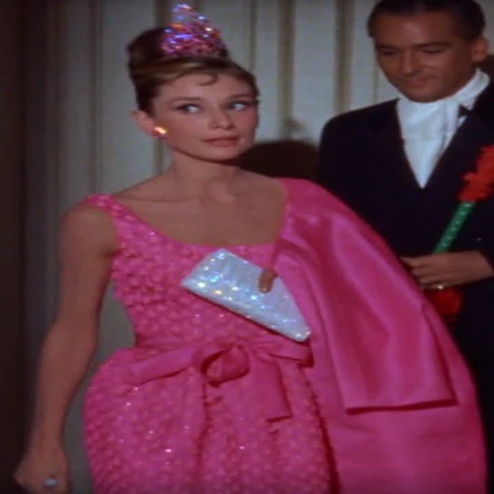 Audrey Hepburn wearing a pink dress in Breakfast at Tiffany's