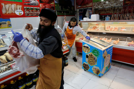 Uighur men work at a halal butcher shop in Zeytinburnu district where most Uighur exiles live in Istanbul, Turkey, December 27, 2018. REUTERS/Murad Sezer