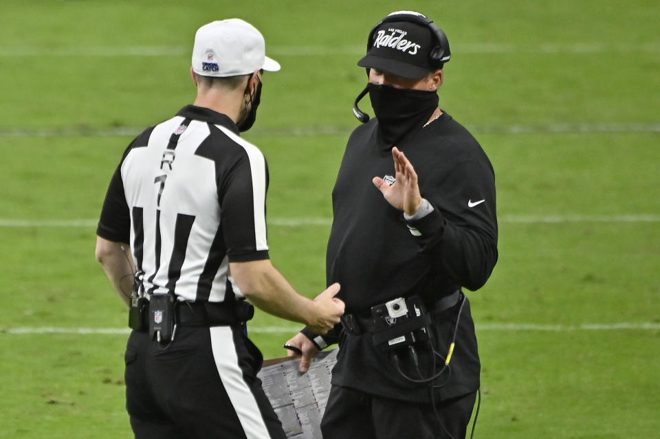 Las Vegas Raiders head coach Jon Gruden, right, speaks with an official during the second half of an NFL football game against the Tampa Bay Buccaneers, Sunday, Oct. 25, 2020, in Las Vegas. (AP Photo/David Becker)