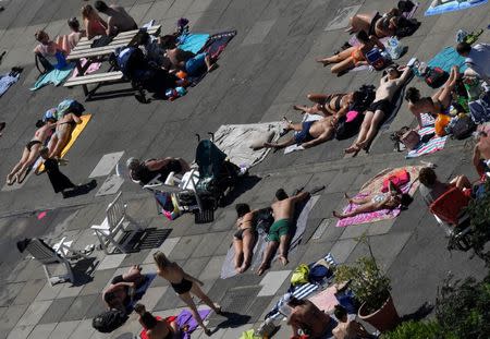 People swim and sunbathe at Brockwell Lido in London, Britain, June 26, 2018. REUTERS/Toby Melville