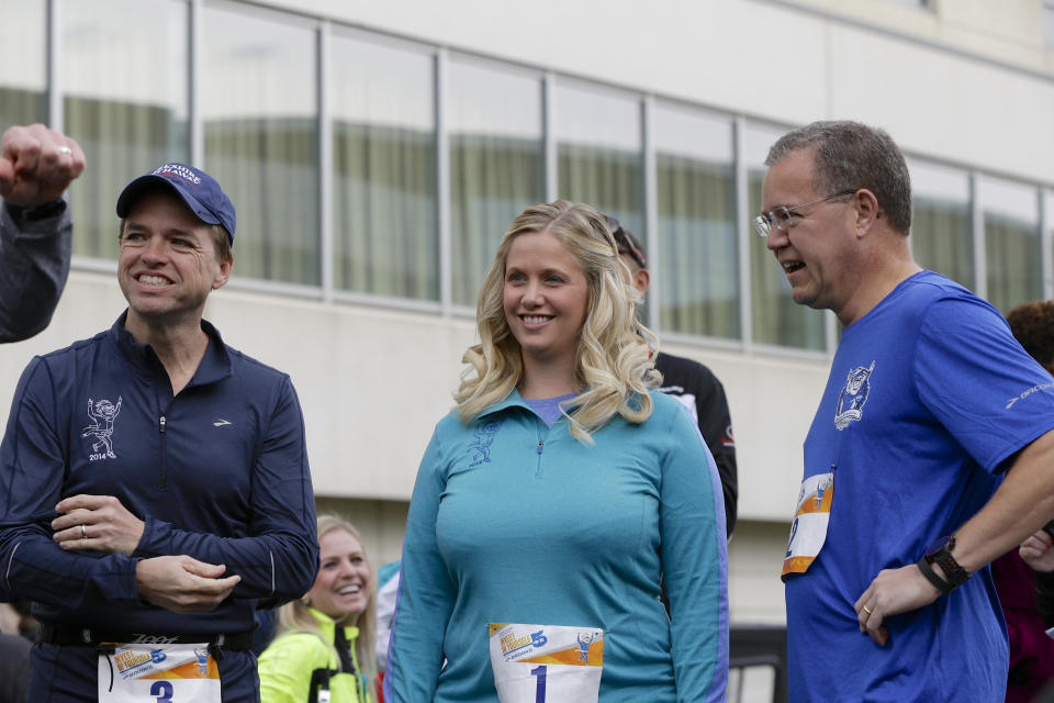 Berkshire Hathaway investment managers Todd Combs, left, Ted Weschler, right, and Tracy Britt Cool, Chairman of Berkshire companies Benjamin Moore, Johns Manville, Oriental Trading Company and Larson-Juhl, center, stand together before a 5K run sponsored by the Brooks Running Company, a Berkshire Hathaway subsidiary. The run is one of the events taking place during Berkshire Hathaway's annual shareholders meeting. (AP Photo/Nati Harnik)