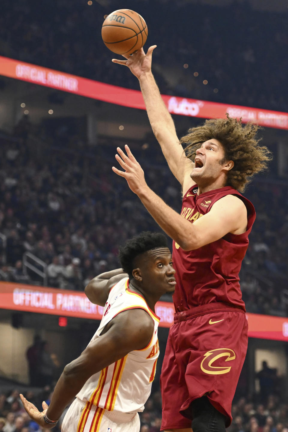 Cleveland Cavaliers center Robin Lopez, right, shoots against Atlanta Hawks center Clint Capela, left, during the first half of an NBA basketball game, Monday, Nov. 21, 2022, in Cleveland. (AP Photo/Nick Cammett)