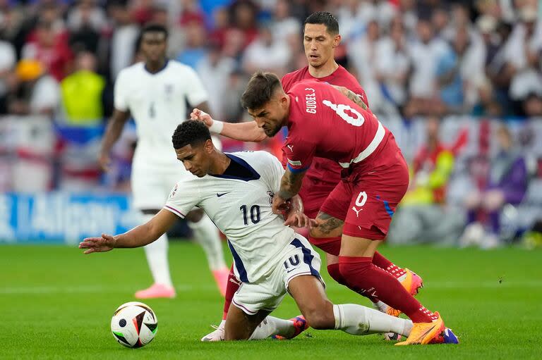 Jude Bellingham cubre la pelota ante la marca de Nemanja Gudelj 