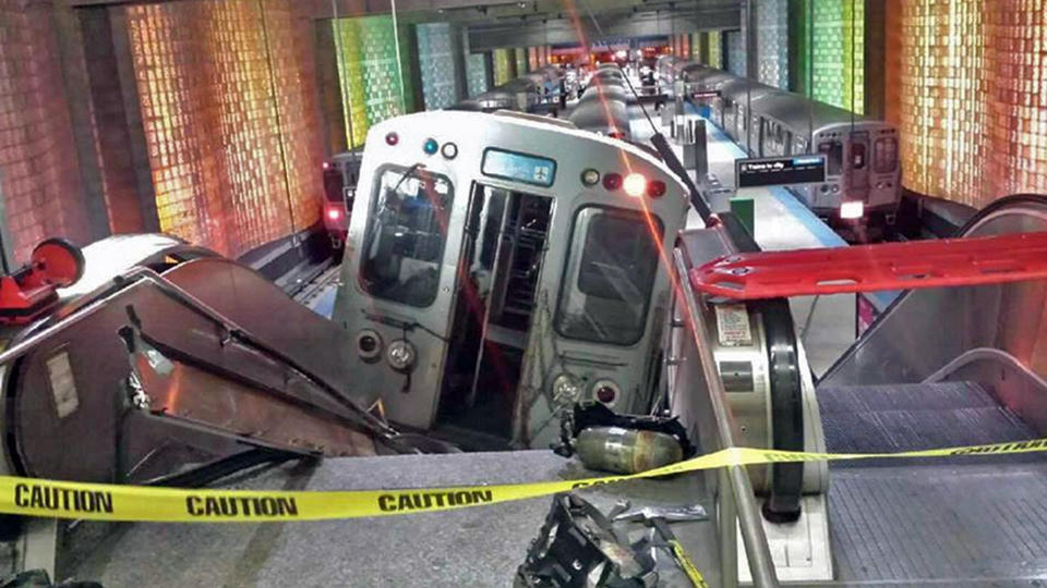 FILE - In this March 24, 2014 file photo, a Chicago Transit Authority train car rests on an escalator at the O'Hare Airport station after it derailed early in the morning, injuring more than 30 people, in Chicago. Had the crash occurred during the day, when the trains are often full and the escalator packed with luggage-carrying travelers, far more people likely would have been injured, some even killed, said Joseph Schwieterman, a transportation expert at DePaul University. (AP Photo/NBC Chicago, Kenneth Webster, File) MANDATORY CREDIT