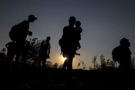 Migrants, hoping to cross into Hungary, walk along a railway track near the village of Horgos in Serbia, towards the border it shares with Hungary, September 1, 2015. REUTERS/Marko Djurica