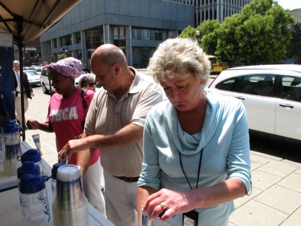 Debbie and Dave Antle draw cold water from the tap on Thursday, June 28, 2012, in Louisville, Ky., as they seek relief from the extreme heat. Louisville Water Co. offered free water from the tap for people in downtown Louisville. (AP Photo/Bruce Schreiner)