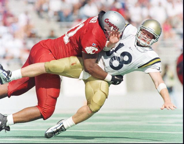 UCLA's Cade McNown is tackled.